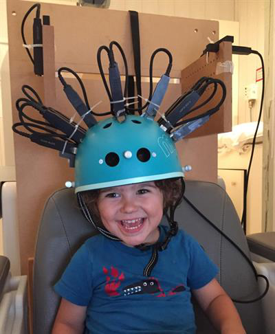 Child undergoing imaging with the MEG helmet scanner